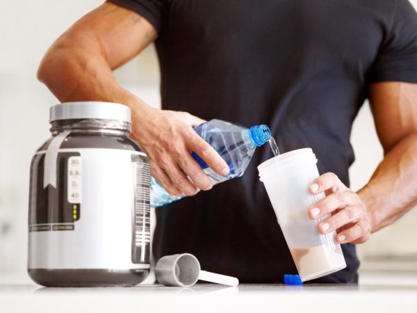 Cropped image of a bodybuilder making himself a protein shake