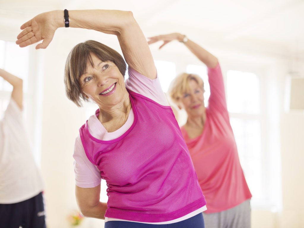 Group of happy seniors practising yoga