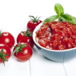 Diced and whole tomatoes. garnished with basil.Diced and whole tomatoes, with olive oil behind.  Garnished with basil.
