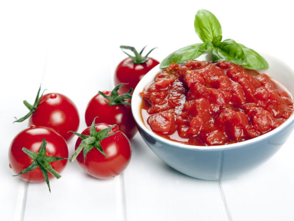 Diced and whole tomatoes. garnished with basil.Diced and whole tomatoes, with olive oil behind.  Garnished with basil.