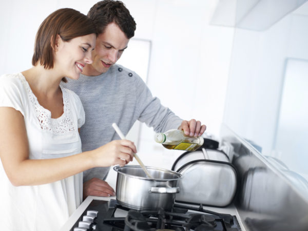 A happy young couple preparing a meal together in the kitchen