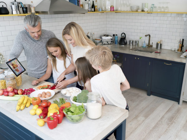 Family cooking dinner together at home and looking very happy. Design  on tablet is own design.