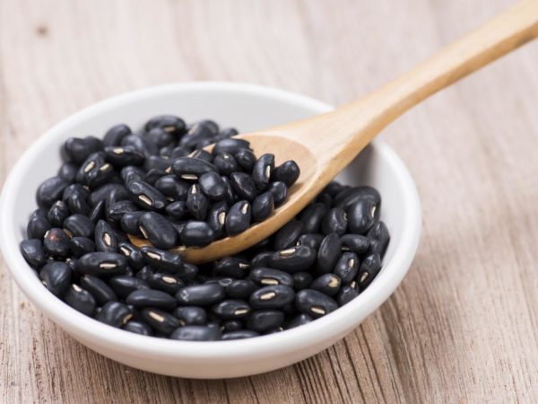 Black Beans in wooden spoon with seramic bowl