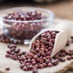 Portion of dried red beans on wooden background (close-up shot)