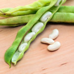 green pod white beans close-up on a wooden table. vegetables, cereals. macro..