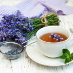 Cup of tea and lavender flowers on a old wooden background