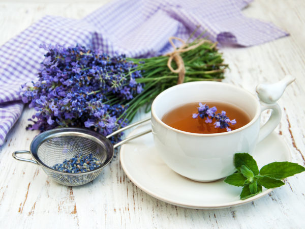 Cup of tea and lavender flowers on a old wooden background