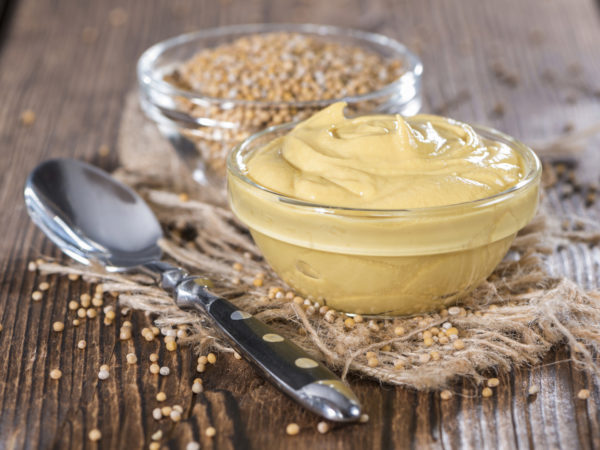 Mustard in a small bowl on vintage wooden backround