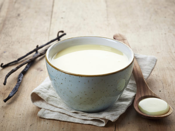 bowl of homemade vanilla sauce on wooden table