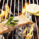 Top view grilled salmon with lemon on the flaming grill