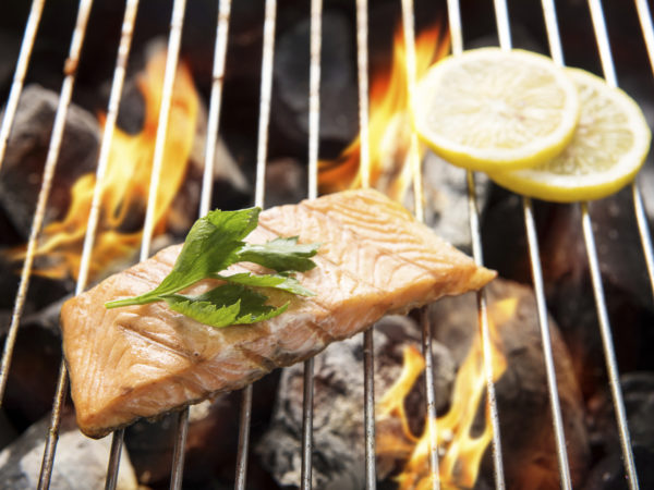 Top view grilled salmon with lemon on the flaming grill