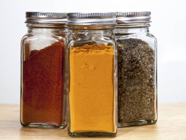 Cayenne pepper, turmeric &amp; Coriander spices in square jars.