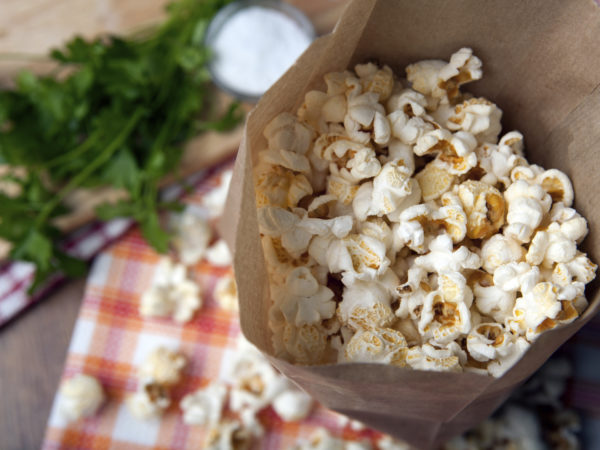 fresh salted popcorn in a paper bag close up