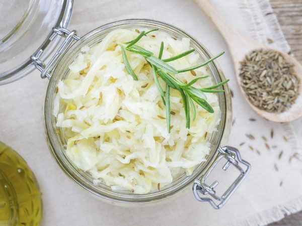 Homemade sauerkraut with cumin in a glass jar, top view