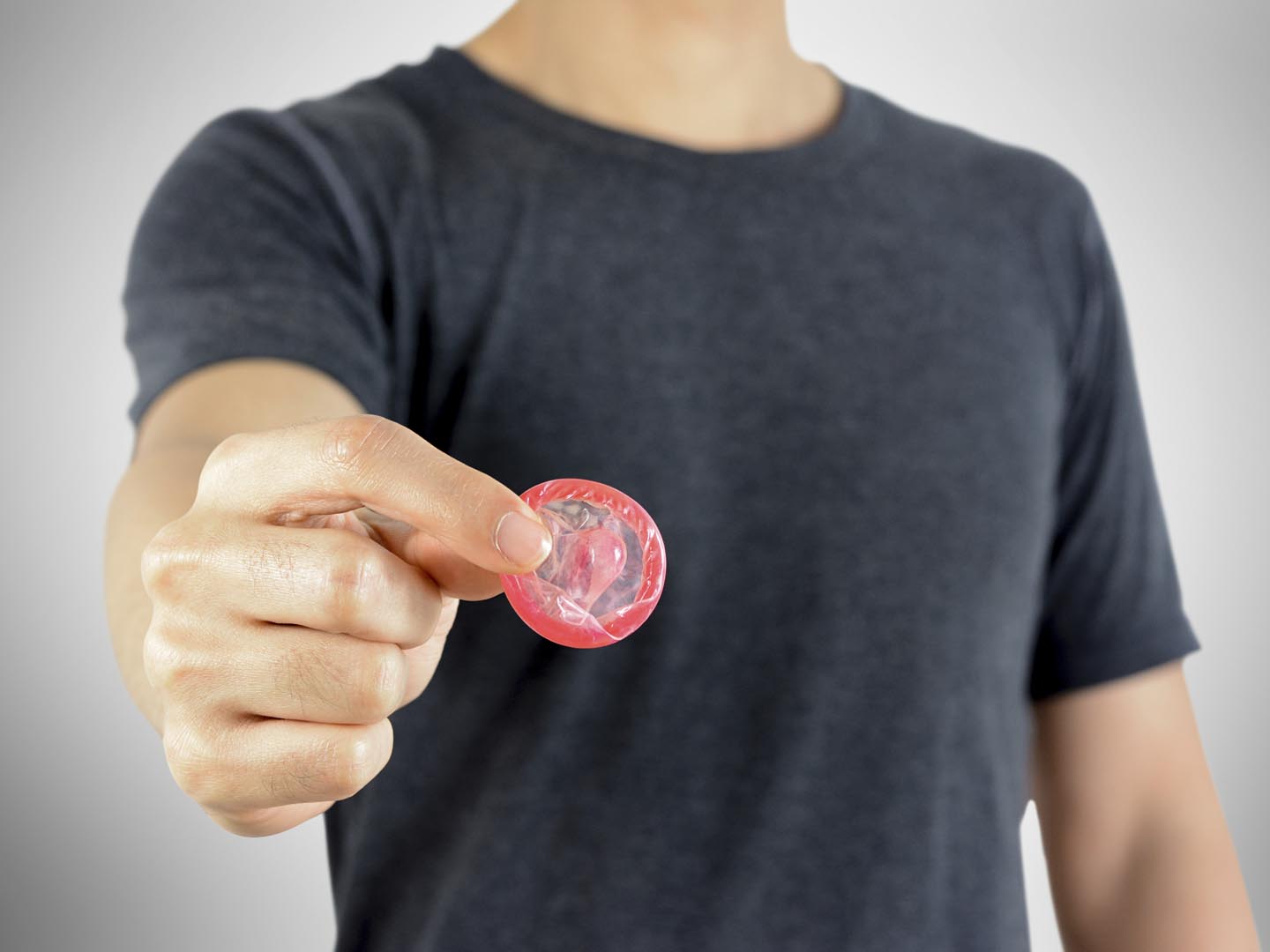 Young man giving condom, sexaul transmitted disease protection concept