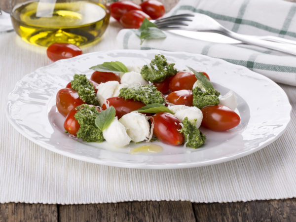 Caprese. Italian salad - mozzarella, tomato, basil, pesto.