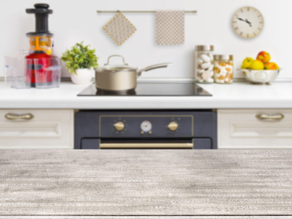 Wooden table on defocused kitchen bench with oven background