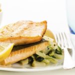 Fried fish fillets with vegetable garnish on white