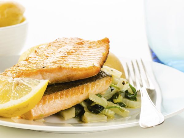 Fried fish fillets with vegetable garnish on white