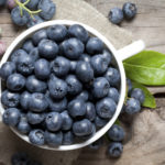 Delicious blueberry in bowl on old table. This file is cleaned and retouched.