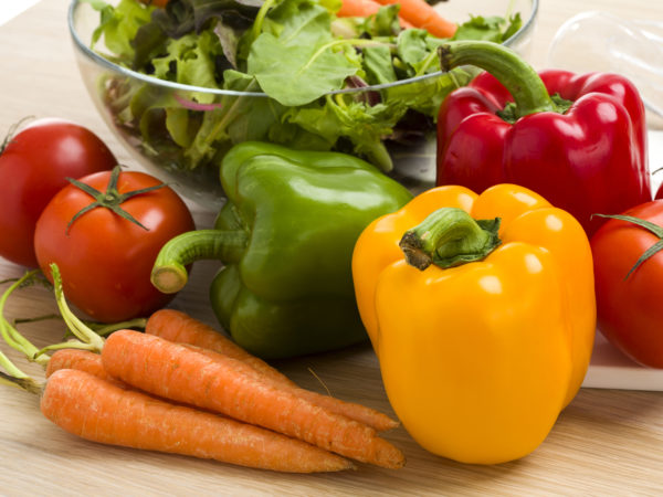 Mix of vegetables on salad on the wood table background.