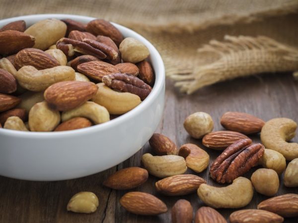 Mixed nuts on wooden table and bowl