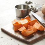 preparation of sweet potatoes on cutting board.