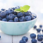 Blueberries in a bowl with leafs of mint