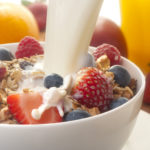 Healthy muesli breakfast with milk being poured over it