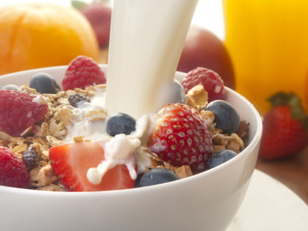 Healthy muesli breakfast with milk being poured over it