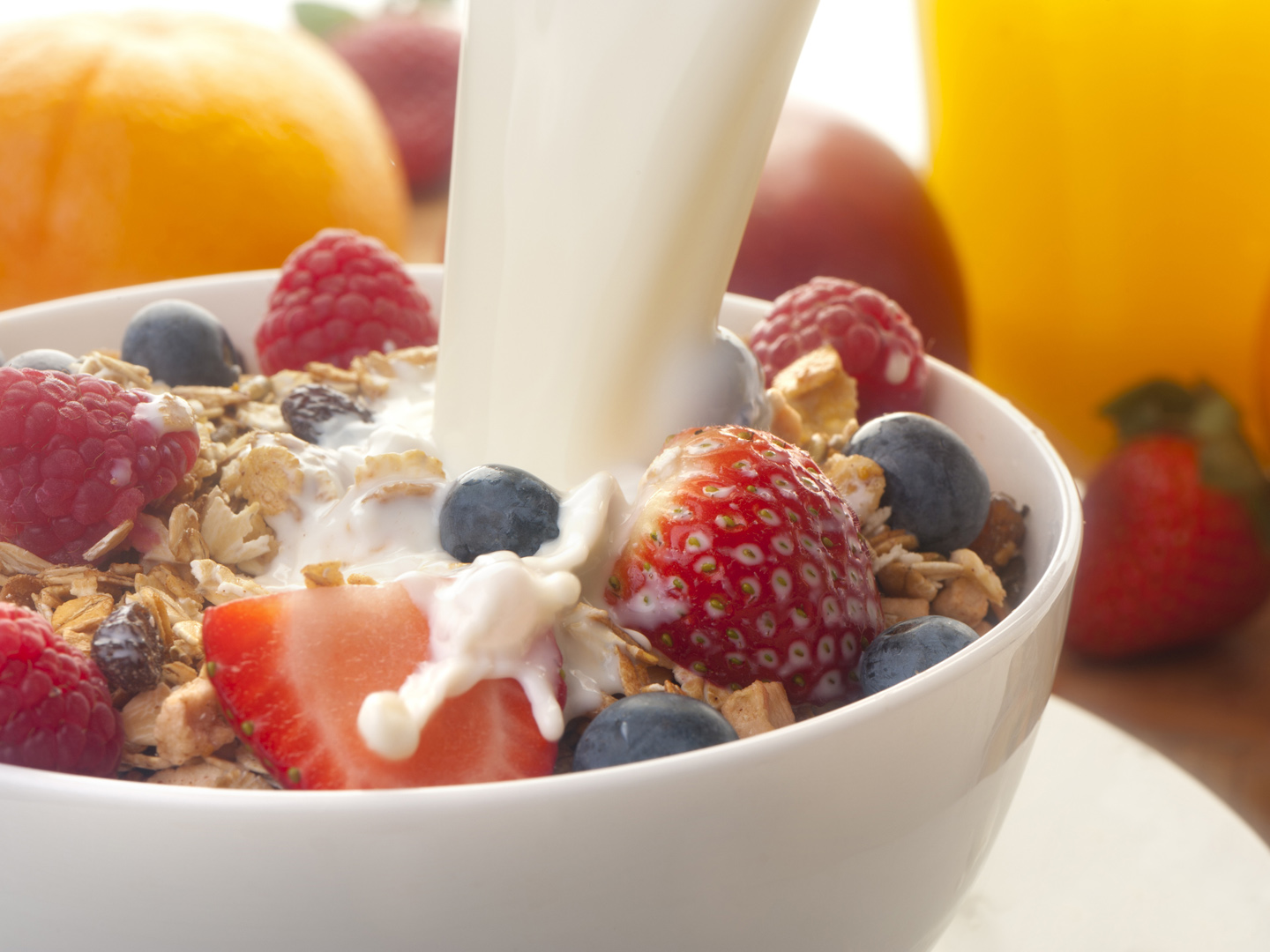 Healthy muesli breakfast with milk being poured over it