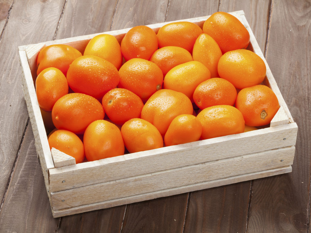 Orange tomatoes box on wooden table