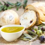 Ciabatta bread with olive oil and olive branch on burlap.