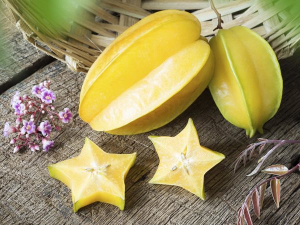 star fruit and piece with it&#039;s flower and leaf on old wood