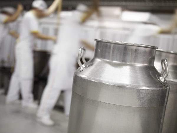 milk container in the foreground in a dairy factory