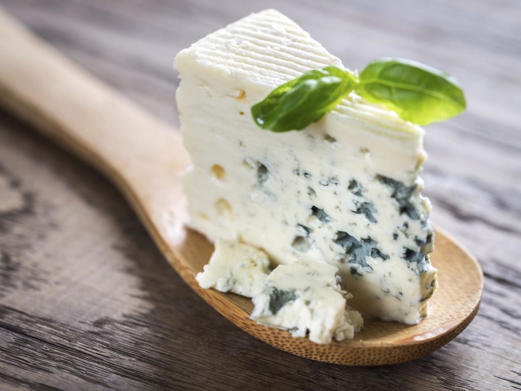 Piece of the blue cheese on the wooden spoon
