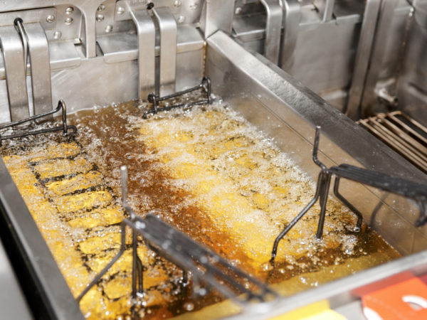 Deep fryer with boiling oil on restaurant kitchen