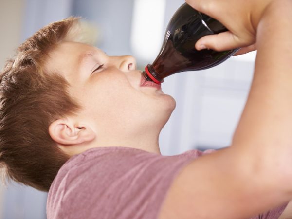 Close Up Of Boy Drinking Soda From Bottle