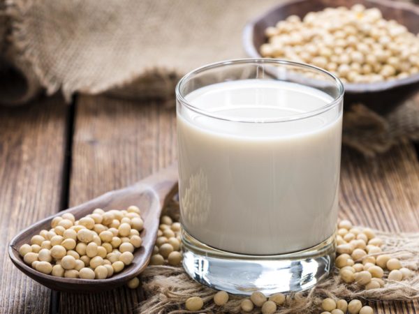 Glass with Soy Milk and Seeds on wooden background