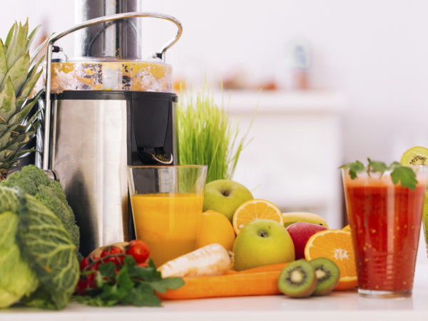 Making a healthy drink with fruit and vegetables by using an electric juicer
