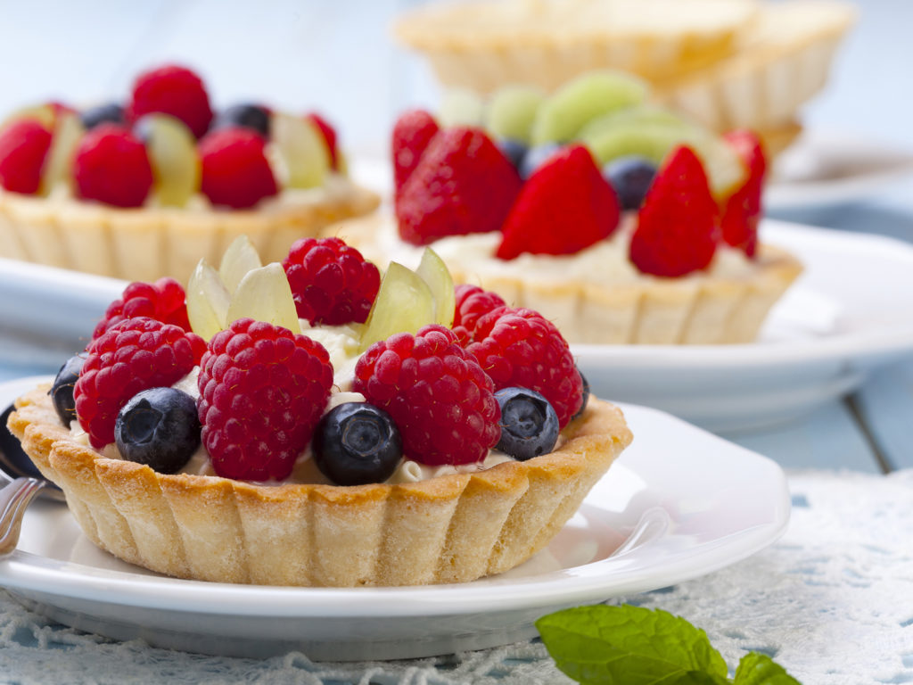 Delicious tartlets with fruit and cream mascaropne on plate