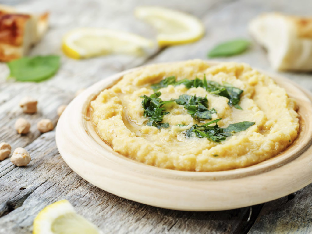 lemon hummus with Basil dressing on a dark wood background. the toning. selective focus