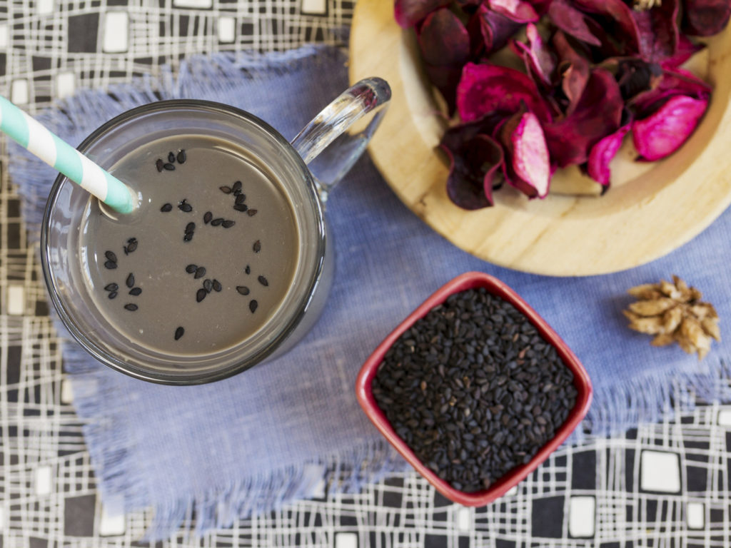 Black sesame milk and sesame seed. High angle. Sesame seed milk in a glass. Focus on the glass.