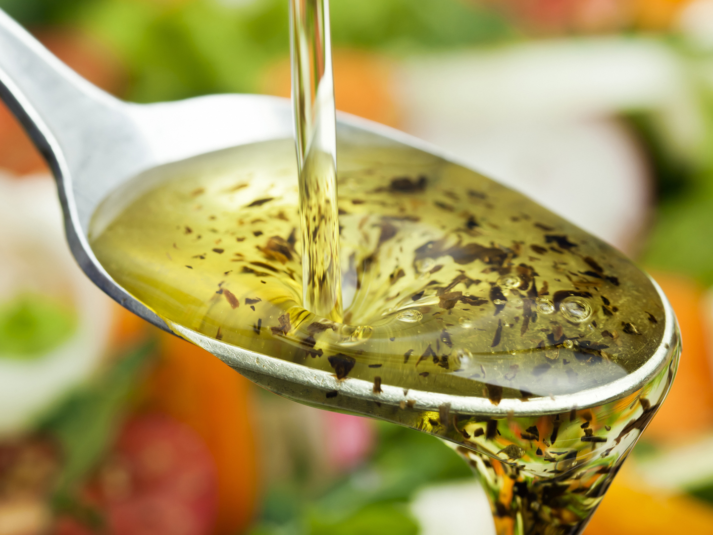 Olive oil pouring over salad.