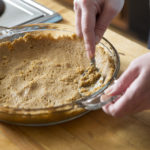 Spreading a graham cracker crust in a pie pan.  See my portfolio for more in this series of making a banana-blueberry cream pie.