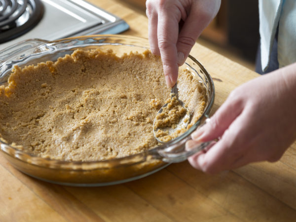 Spreading a graham cracker crust in a pie pan.  See my portfolio for more in this series of making a banana-blueberry cream pie.