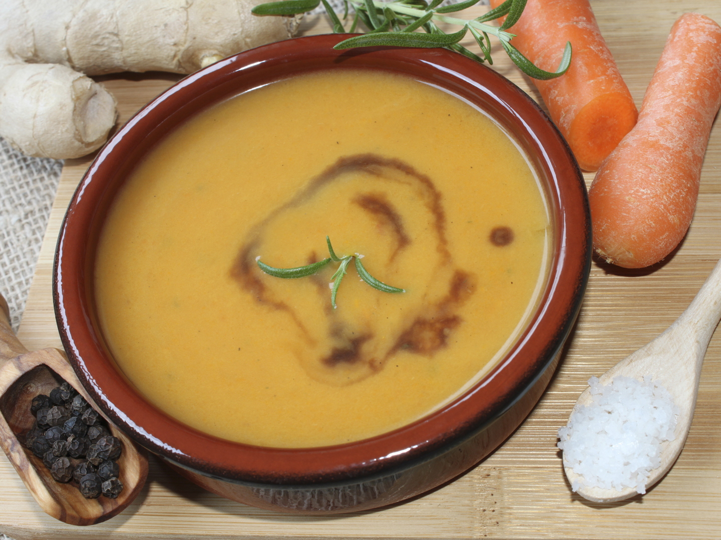 healthy carrot soup with ingredients around