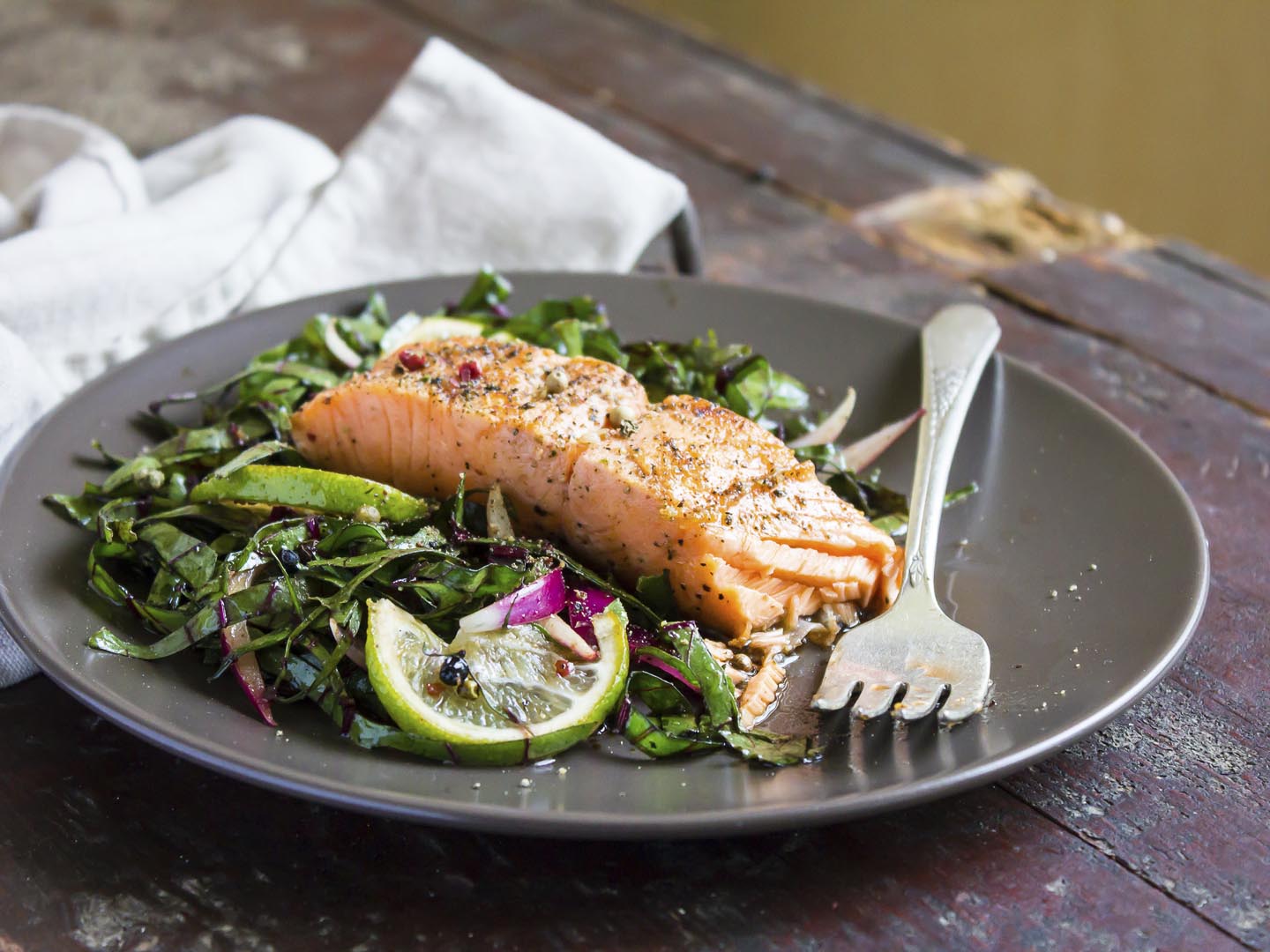 Roasted salmon fillet with fresh salad with onion and lime in a plate, selective focus