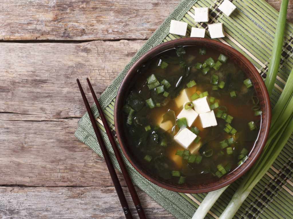 Japanese miso soup in a brown bowl on the table. horizontal view from above