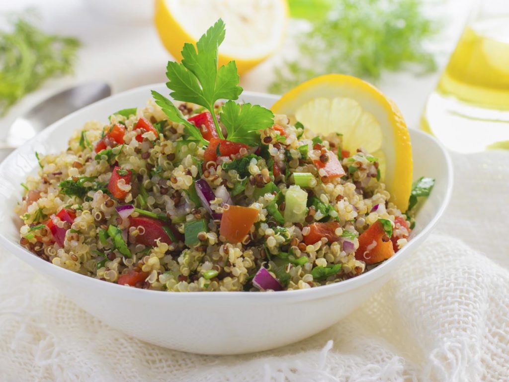 Tabbouleh salad with quinoa, parsley and vegetables on white background